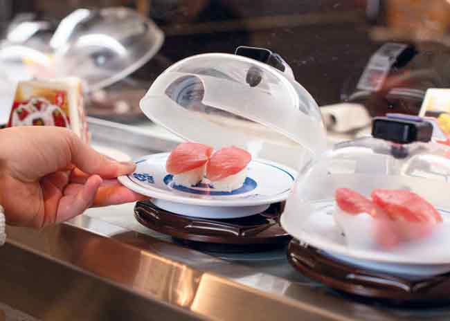 At Kura Sushi, plates are protected by a ventilated sushi lid, which limits airborne exposure.  Photo courtesy of Emily J. Davis
