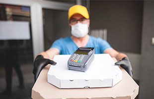 Pizza Deliverer with mask and credit card machine