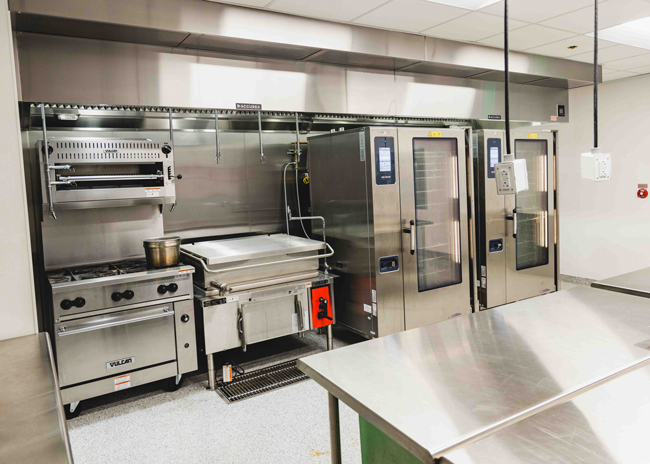 A range with an overhead salamander, a tilt skillet and combi ovens support production in the back of the house.