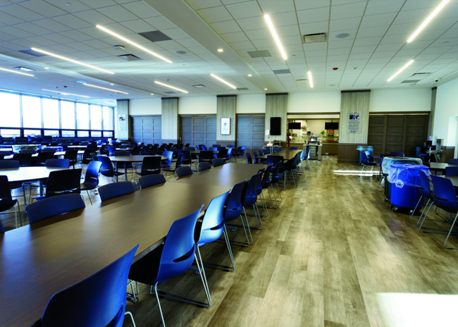 Students dine in a room filled with natural light and LED lights. 