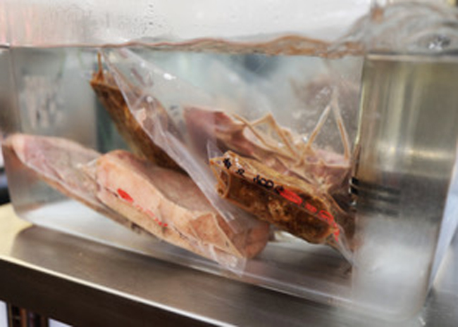 Sous vide is a cooking method that vacuum seals meat in a specially designed pouch and then cooks it at slightly lower-than-usual temperatures in a circulating water bath.