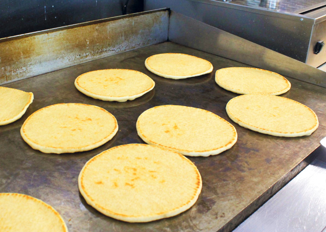 The flattop grill at Mezze Table at Georgia Gwinnett College serves double duty in preparing diverse menu items, such as meat and pita bread.