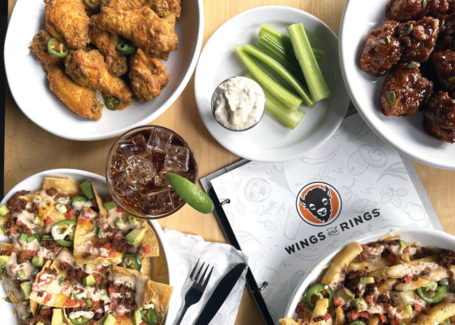 Wings and Rings, an 85-unit, Cincinnati-based restaurant and sports bar franchise, spiced up its menu this fall with two new wing sauces and a limited-time offer. The chain added Curry Garlic and Pumpkin Chile sauces to its line of wings. And it offered Chorizo Loaded Fries and Nachos for a limited time. Wings and Rings also introduced a Spiced Spiked Vanilla Coke.