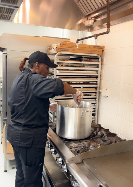 Raveon Armstrong stirs a pot of pasta at the six-burner range.