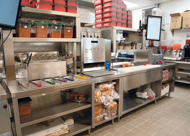 The main assembly lines at Houston TX Hot Chicken include a seasoning station, a toaster for buns and a sandwich table.