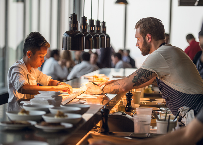 At Manhatta restaurant in New York City, the service station’s decorative heat lamps keep dishes at optimum temperatures before serving. Photo by Daniel Krieger, photo courtesy of Ricca Design