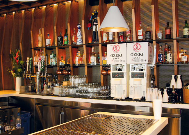 At Hapa Sushi, which has four locations in and around Denver, the bar is stocked with glassware and decanters amongst the alcohol on display for fast service.  Photo courtesy of Ricca Design