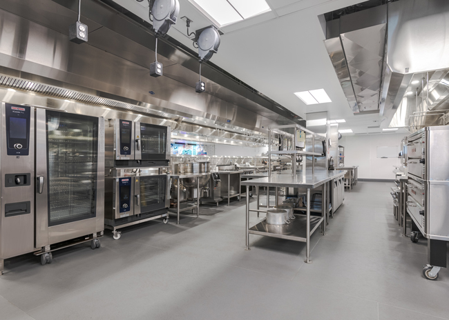 Overhead power cord reels and casters on equipment are two small but important elements that provide maximum flexibility. A wall cutout enables guests to see the culinary team in action.