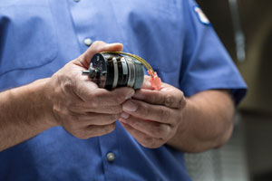 Heritage Technician Holding a Part