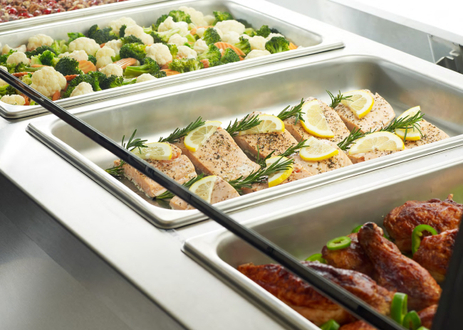 Hot food wells maintain entrées and vegetables at safe serving temperatures during peak hours.