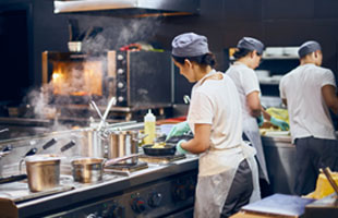 Chefs in restaurant kitchen preparing food